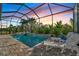 Enclosed pool area with stone coping and lounge chairs at 10201 Beach Dune Dr, Englewood, FL 34223