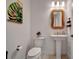 Chic powder room with pedestal sink, toilet, and decorative mirror at 10201 Beach Dune Dr, Englewood, FL 34223