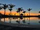 Relaxing resort-style pool at sunset, with palm trees and lounge chairs at 10201 Beach Dune Dr, Englewood, FL 34223