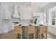 Modern kitchen with white cabinets, a large island, and a range hood at 11124 Sanctuary Dr, Bradenton, FL 34209