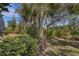 Lush tropical landscaping with mature trees and shrubs at 12366 Marsh Pointe Rd, Sarasota, FL 34238