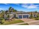 Well-maintained house featuring a gray garage door and lush landscaping at 12366 Marsh Pointe Rd, Sarasota, FL 34238