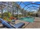 Screened pool and spa with lounge chairs and lush landscaping at 12366 Marsh Pointe Rd, Sarasota, FL 34238