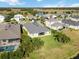 Aerial view of houses in a community by the lake featuring backyard pools and lush landscaping at 14822 Trinity Fall Way, Bradenton, FL 34212