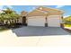 House exterior with three-car garage and palm trees at 14822 Trinity Fall Way, Bradenton, FL 34212