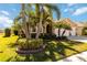 Landscaped yard with palm trees and a tan house with a three car garage at 14822 Trinity Fall Way, Bradenton, FL 34212