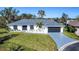 An aerial view of a single-Gathering home with a gray driveway and green lawn at 1608 Honey Ct, Venice, FL 34293