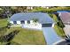 Aerial view of a house with a gray driveway and white exterior at 1608 Honey Ct, Venice, FL 34293