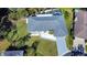 An aerial view of a house with a gray driveway and a well-manicured lawn at 1608 Honey Ct, Venice, FL 34293