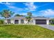 White house with dark garage door and landscaping at 1608 Honey Ct, Venice, FL 34293