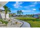 Landscaped walkway leading to a quiet neighborhood with palm trees at 1608 Honey Ct, Venice, FL 34293