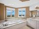 Luxurious bathroom with soaking tub, marble finishes, and water views at 2050 Benjamin Franklin Dr # A601, Sarasota, FL 34236