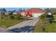 Concrete driveway leading to a peach single-story house with a brown roof and attached garage at 2421 Palomar St, North Port, FL 34287