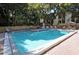 Community pool with surrounding lounge chairs and patio at 2723 Orchid Oaks Dr # 104, Sarasota, FL 34239