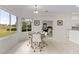 Bright breakfast nook with glass table and white chairs, view of backyard at 2763 Phoenix Palm Ter, North Port, FL 34288