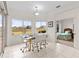 Breakfast nook with glass table and four white chairs, view into bedroom at 2763 Phoenix Palm Ter, North Port, FL 34288