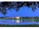 Evening view of a home on the lake, beautifully lit at 282 Shell Midden Ct, Osprey, FL 34229