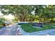 Gated entrance to Bay Isles Beach Club, featuring a lush landscape and brick pavers at 3010 Grand Bay Blvd # 493, Longboat Key, FL 34228