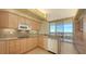 Well-equipped kitchen with light wood cabinets and granite countertops at 3010 Grand Bay Blvd # 493, Longboat Key, FL 34228