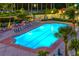 Illuminated pool at night with surrounding lounge area at 3010 Grand Bay Blvd # 493, Longboat Key, FL 34228