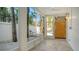 Covered patio with tile flooring, tropical landscaping and a wooden door at 345 Madison Dr, Sarasota, FL 34236