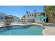 Large kidney shaped pool with patio furniture and a teal umbrella at 345 Madison Dr, Sarasota, FL 34236