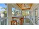 Relaxing screened porch with wooden table and chairs, offering outdoor dining space at 345 Madison Dr, Sarasota, FL 34236