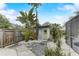 Cute backyard shed with a light green door, surrounded by cacti and palms at 3822 75Th E Ter, Sarasota, FL 34243