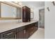 Double vanity bathroom with dark brown cabinets and a shower at 400 Golden Gate Pt # 11, Sarasota, FL 34236