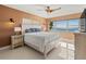 Bedroom with water view, ceiling fan, and white bed at 400 Golden Gate Pt # 11, Sarasota, FL 34236