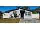 Modern single story home with gray exterior, paver driveway, and white fence at 4029 9Th S Ave, St Petersburg, FL 33711