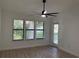 Bedroom with three windows, ceiling fan, and door to balcony at 4041 Crockers Lake Blvd # 24, Sarasota, FL 34238