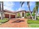Luxury home with three-car garage, brick driveway, and lush landscaping at 4110 Commodore Blvd, Cortez, FL 34215