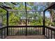 Screened porch with wooden deck and lush green view at 4351 Trails Dr # 4-2, Sarasota, FL 34232