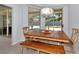 Bright dining area with wooden table and bench, and sliding door access to backyard at 4679 Country Manor Dr, Sarasota, FL 34233