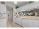 Galley-style kitchen with white cabinets and pass-through to dining area at 4705 Sand Trap Street E Cir # 106, Bradenton, FL 34203