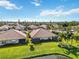 Aerial view of houses, lush landscape, and a pond at 4891 Maymont Park Cir, Bradenton, FL 34203