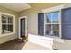 Front entrance with a door, windows, and neutral-colored walls at 4891 Maymont Park Cir, Bradenton, FL 34203