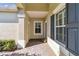 Covered front porch with neutral colored walls and dark shutters at 4891 Maymont Park Cir, Bradenton, FL 34203