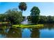 Serene pond with a central fountain, palm trees, and lush greenery at 5269 Myrtle Wood Rd # 35, Sarasota, FL 34235