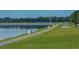 Scenic paved path alongside a lake with green grass and trees at 5269 Myrtle Wood Rd # 35, Sarasota, FL 34235