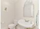 Powder room with pedestal sink, toilet, and decorative mirror at 531 N Spoonbill Dr, Sarasota, FL 34236