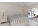 Bedroom with pool view, white wooden bed frame and sliding doors to patio at 531 N Spoonbill Dr, Sarasota, FL 34236