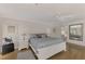 Bright bedroom with white wooden bed frame, ceiling fan, and hardwood floors at 531 N Spoonbill Dr, Sarasota, FL 34236