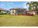 Landscaped backyard with lush lawn and view of home's back at 5337 Popoli Way, Sarasota, FL 34238