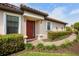 Inviting front entrance with a red door and well-manicured landscaping at 5337 Popoli Way, Sarasota, FL 34238