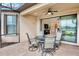 Covered patio with seating area, glass table, and view of the backyard at 5337 Popoli Way, Sarasota, FL 34238