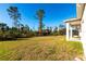 Spacious grassy backyard with a view of surrounding trees and houses at 5534 Fairlane Dr, North Port, FL 34288