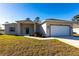 New construction home with a landscaped lawn and attached garage at 5534 Fairlane Dr, North Port, FL 34288