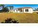 View of house exterior and backyard, showcasing a large grassy area at 5534 Fairlane Dr, North Port, FL 34288